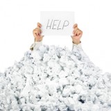 Person under crumpled pile of papers with a help sign / isolated